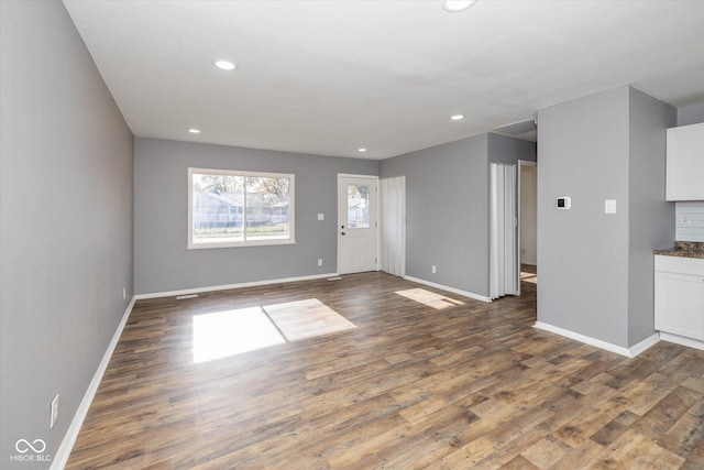 unfurnished living room with dark wood-type flooring