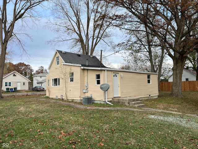 back of house with a lawn and central AC