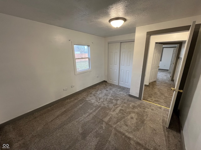 unfurnished bedroom featuring a closet, a textured ceiling, and dark carpet