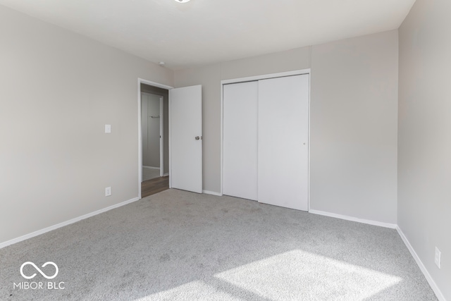 unfurnished bedroom featuring carpet flooring and a closet