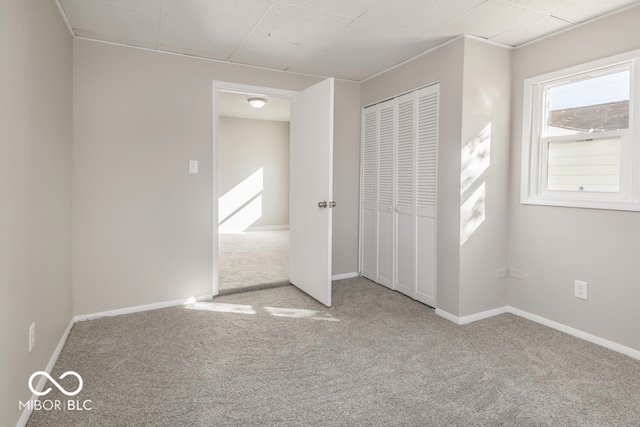 unfurnished bedroom with light carpet and a closet