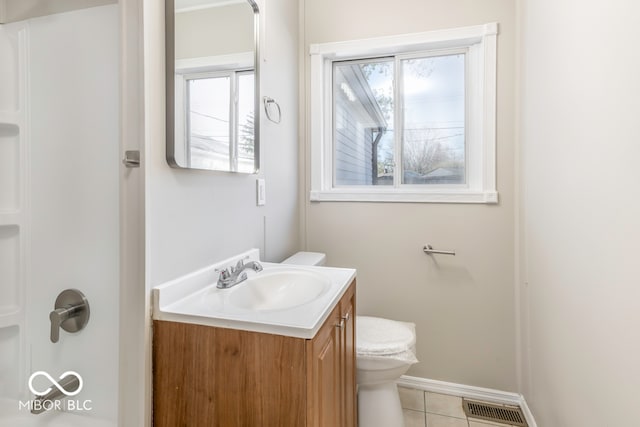 bathroom with vanity, tile patterned flooring, a healthy amount of sunlight, and toilet