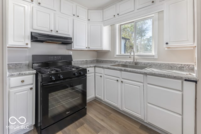 kitchen with black gas range, light hardwood / wood-style floors, white cabinetry, and sink