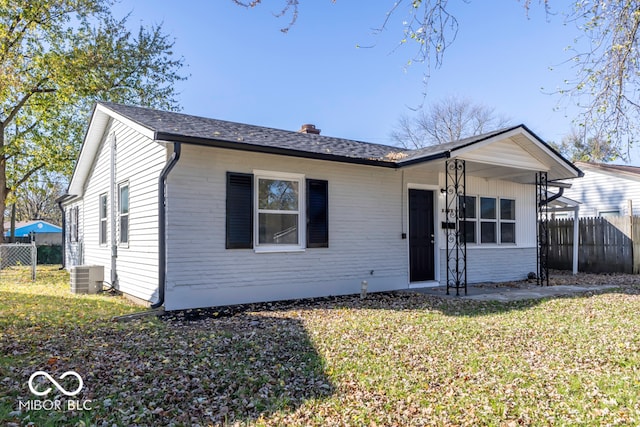 ranch-style house featuring cooling unit and a front lawn