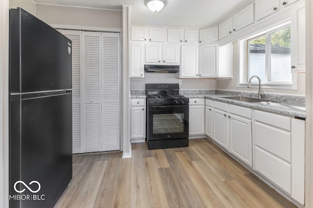 kitchen featuring white cabinets, sink, black appliances, and light wood-type flooring