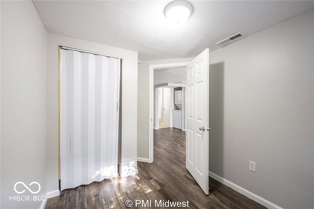 unfurnished bedroom with dark hardwood / wood-style flooring and a closet