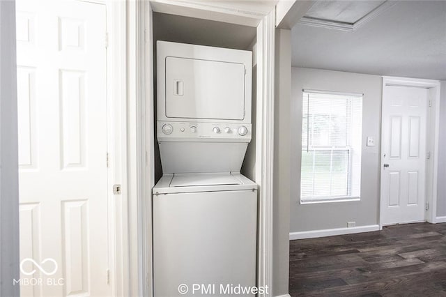 clothes washing area with dark hardwood / wood-style floors and stacked washer / dryer