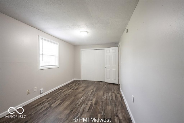 interior space with a textured ceiling and dark hardwood / wood-style flooring