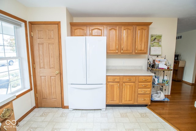 kitchen featuring light hardwood / wood-style flooring, white fridge, and a healthy amount of sunlight