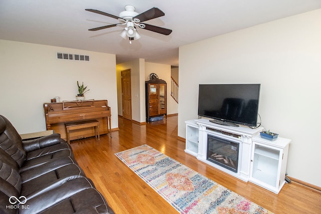 living room with hardwood / wood-style floors and ceiling fan