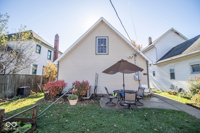 back of property with a patio, cooling unit, and a lawn