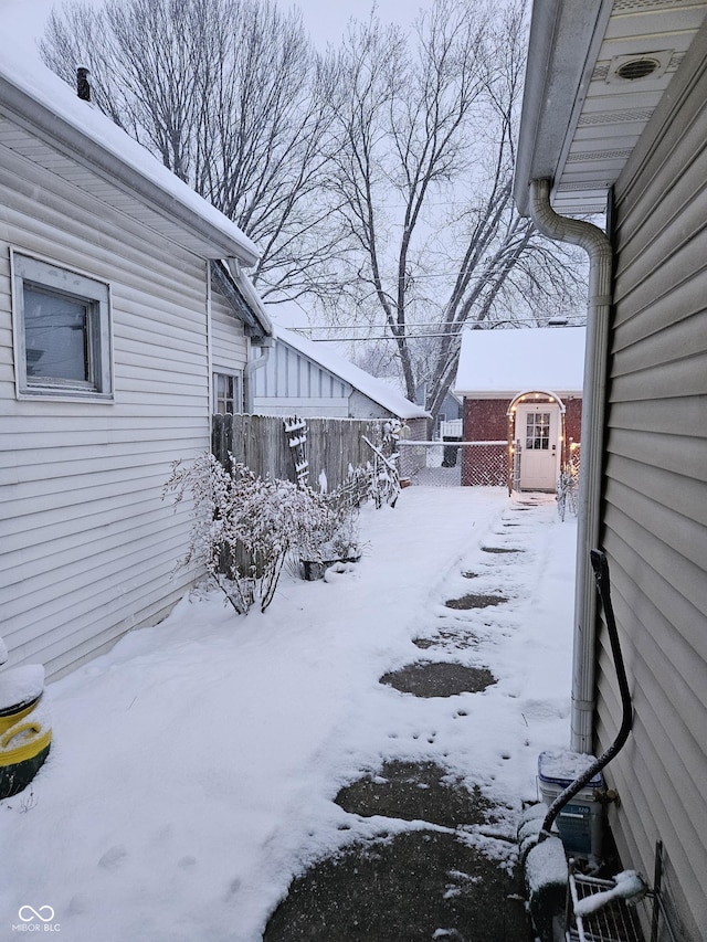 snowy yard featuring a storage unit