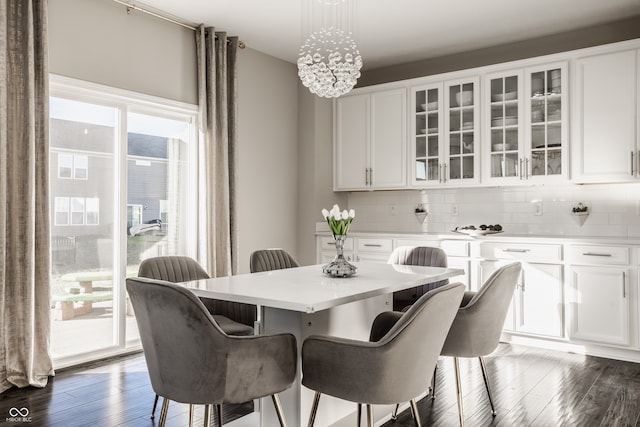 dining room with a notable chandelier, plenty of natural light, and dark wood-type flooring