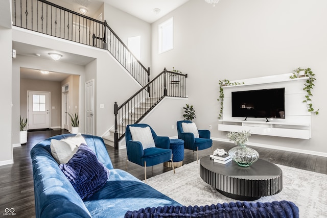 living room with dark wood-type flooring and a high ceiling