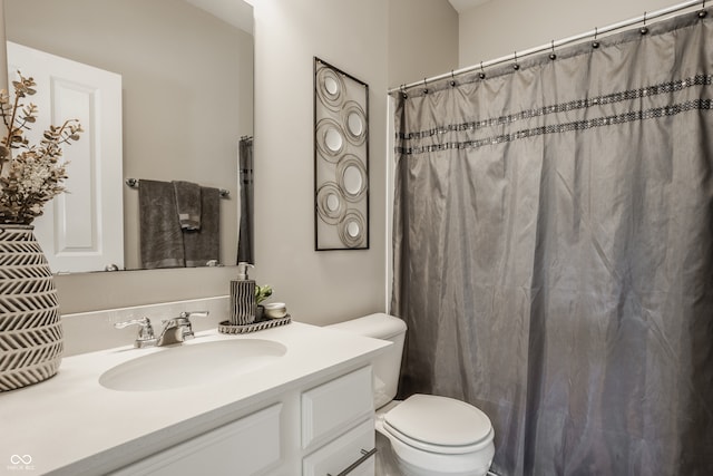 bathroom with vanity, curtained shower, and toilet