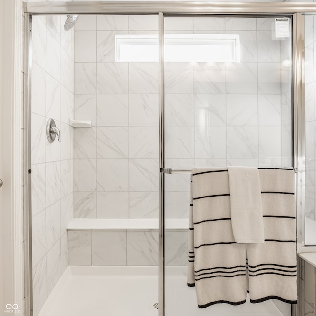 bathroom with a shower with door