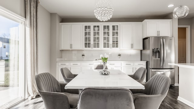 dining area featuring dark wood-type flooring and an inviting chandelier