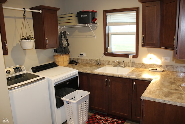 laundry area featuring washer and clothes dryer, cabinets, and sink