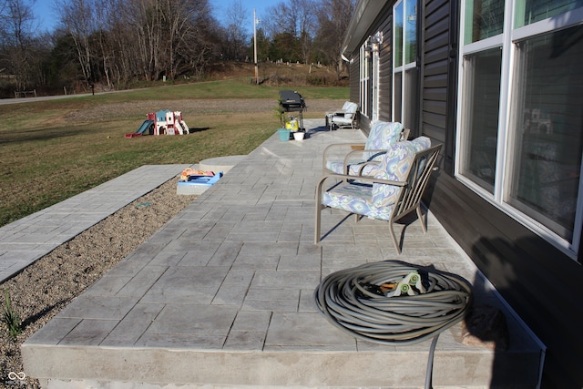 view of patio with a playground and grilling area