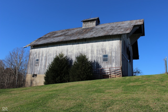 view of side of home featuring an outbuilding and a lawn