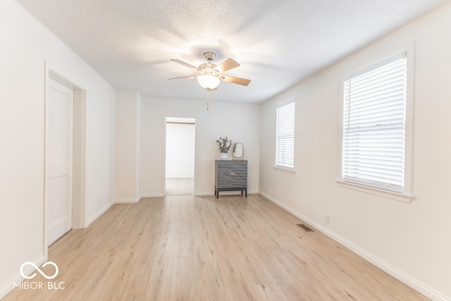 spare room featuring ceiling fan, a textured ceiling, and light hardwood / wood-style flooring