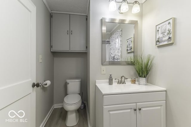 907 S E St, Indianapolis, IN 46225 - half bath featuring vanity, wood finished floors, and a textured ceiling