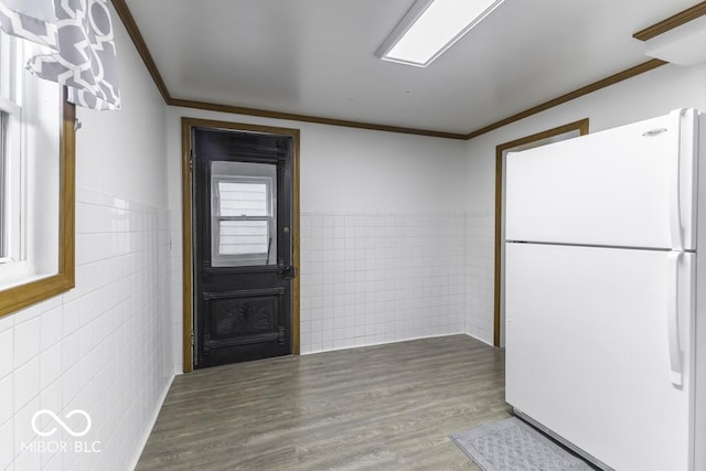 907 S E St, Indianapolis, IN 46225 - kitchen with freestanding refrigerator, tile walls, crown molding, wood finished floors, and a wainscoted wall