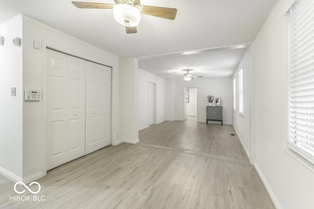 907 S E St, Indianapolis, IN 46225 - unfurnished living room with a ceiling fan, light wood finished floors, and a textured ceiling