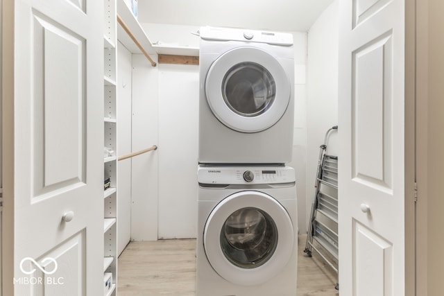 laundry area featuring light wood-type flooring and stacked washer and clothes dryer