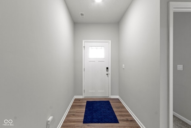 doorway to outside with dark hardwood / wood-style floors and a textured ceiling