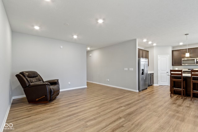 living area with light hardwood / wood-style floors and a textured ceiling