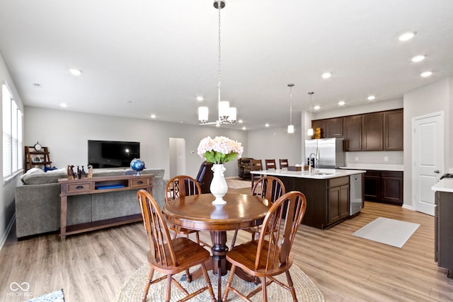 dining room featuring light hardwood / wood-style flooring, a notable chandelier, and sink