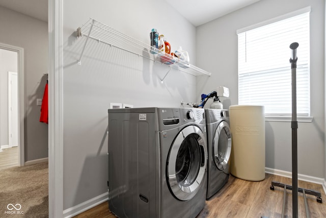 laundry area featuring washing machine and clothes dryer and hardwood / wood-style floors