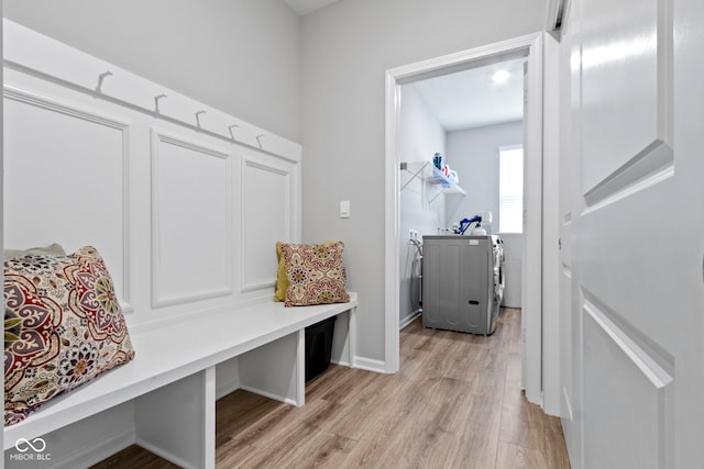 mudroom featuring independent washer and dryer and light hardwood / wood-style flooring