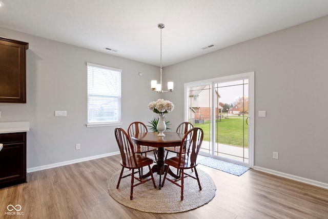 dining area featuring an inviting chandelier and light hardwood / wood-style flooring