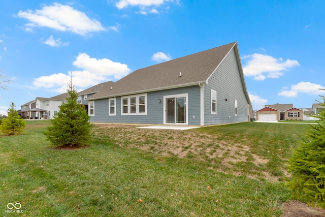 rear view of house featuring a yard, a patio, and a garage