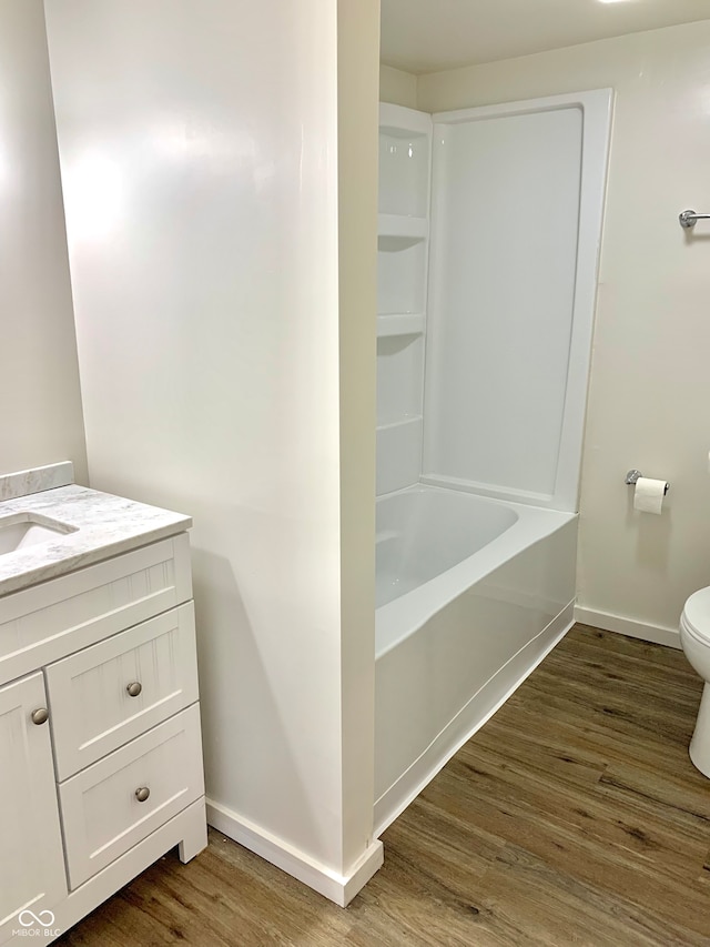 full bathroom featuring hardwood / wood-style floors, vanity, toilet, and shower / bathing tub combination