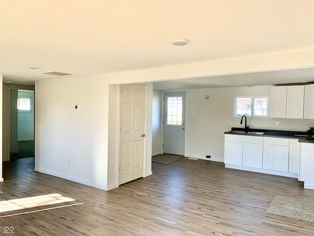 kitchen with white cabinetry, sink, and light hardwood / wood-style floors