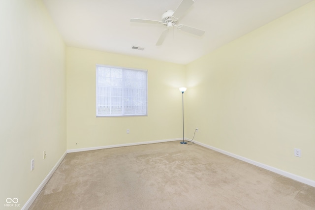 empty room featuring ceiling fan and light carpet