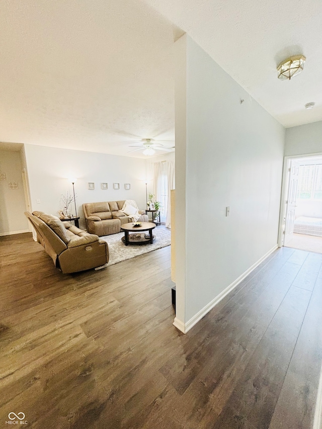 living room with ceiling fan and dark hardwood / wood-style flooring