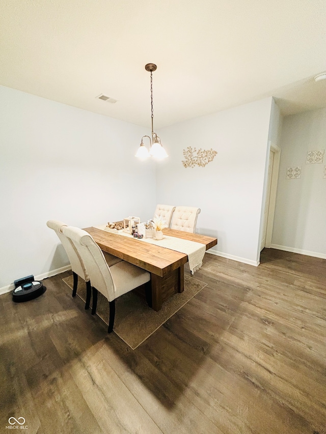 dining room with a notable chandelier and dark hardwood / wood-style flooring