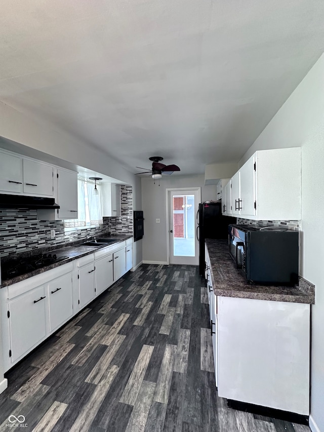 kitchen with backsplash, white cabinets, a healthy amount of sunlight, and black appliances