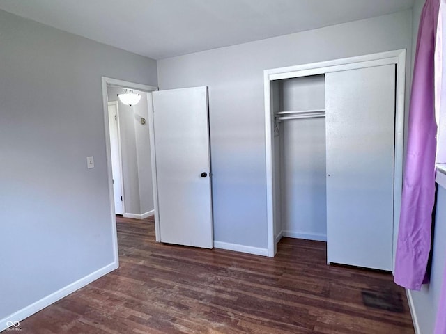 unfurnished bedroom featuring dark wood-type flooring and a closet