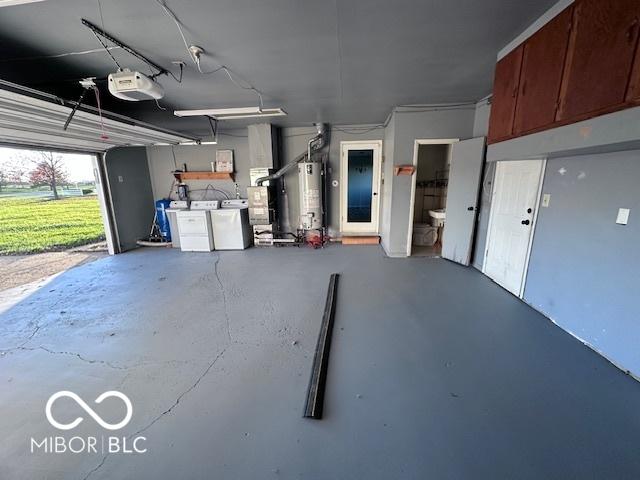 garage featuring washer and dryer, a garage door opener, and water heater