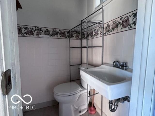 bathroom with tile walls and toilet