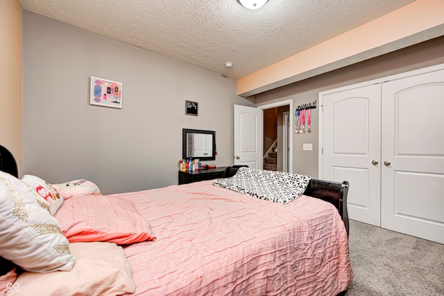 carpeted bedroom featuring a closet and a textured ceiling