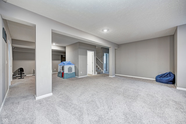 basement featuring carpet and a textured ceiling