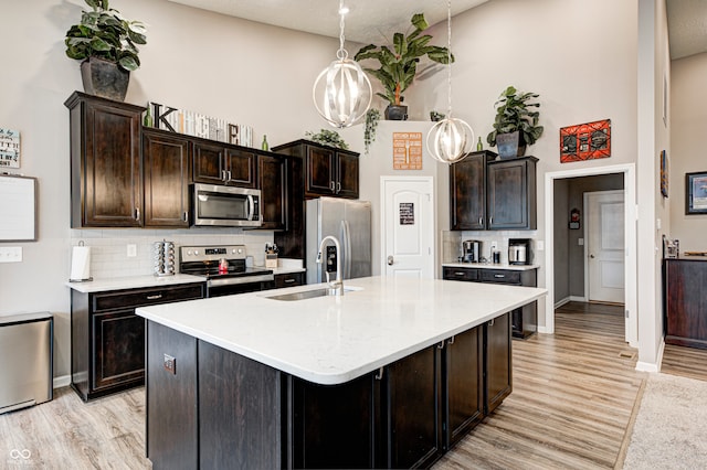 kitchen featuring a textured ceiling, dark brown cabinetry, and stainless steel appliances