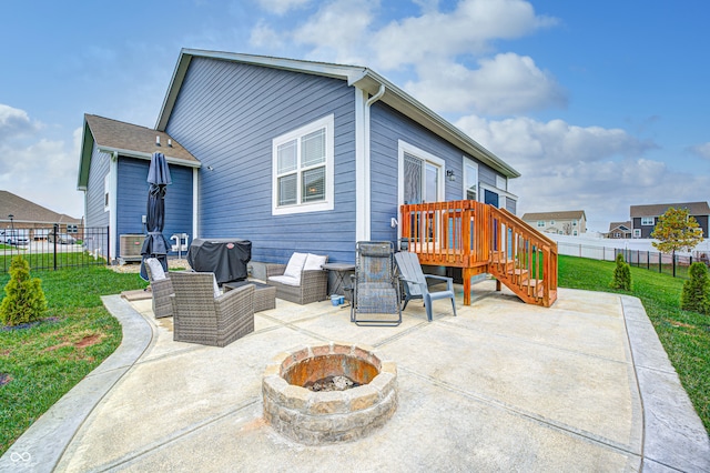 rear view of property with a lawn, a patio area, and an outdoor living space with a fire pit