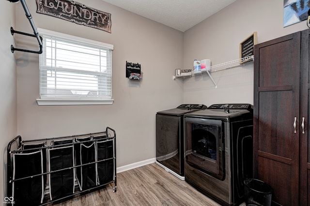 laundry area featuring a textured ceiling, washing machine and dryer, and hardwood / wood-style flooring